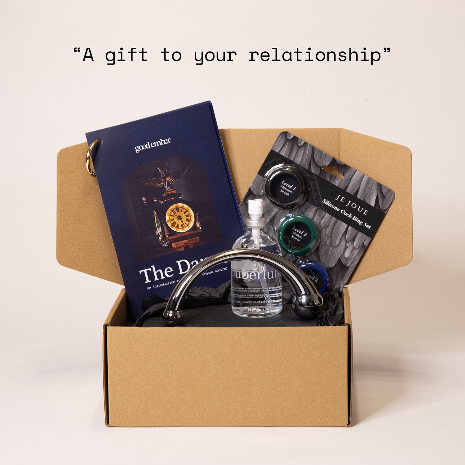 Open box containing cock rings, njoy wand, uberlube and a booklet. The quote reads 